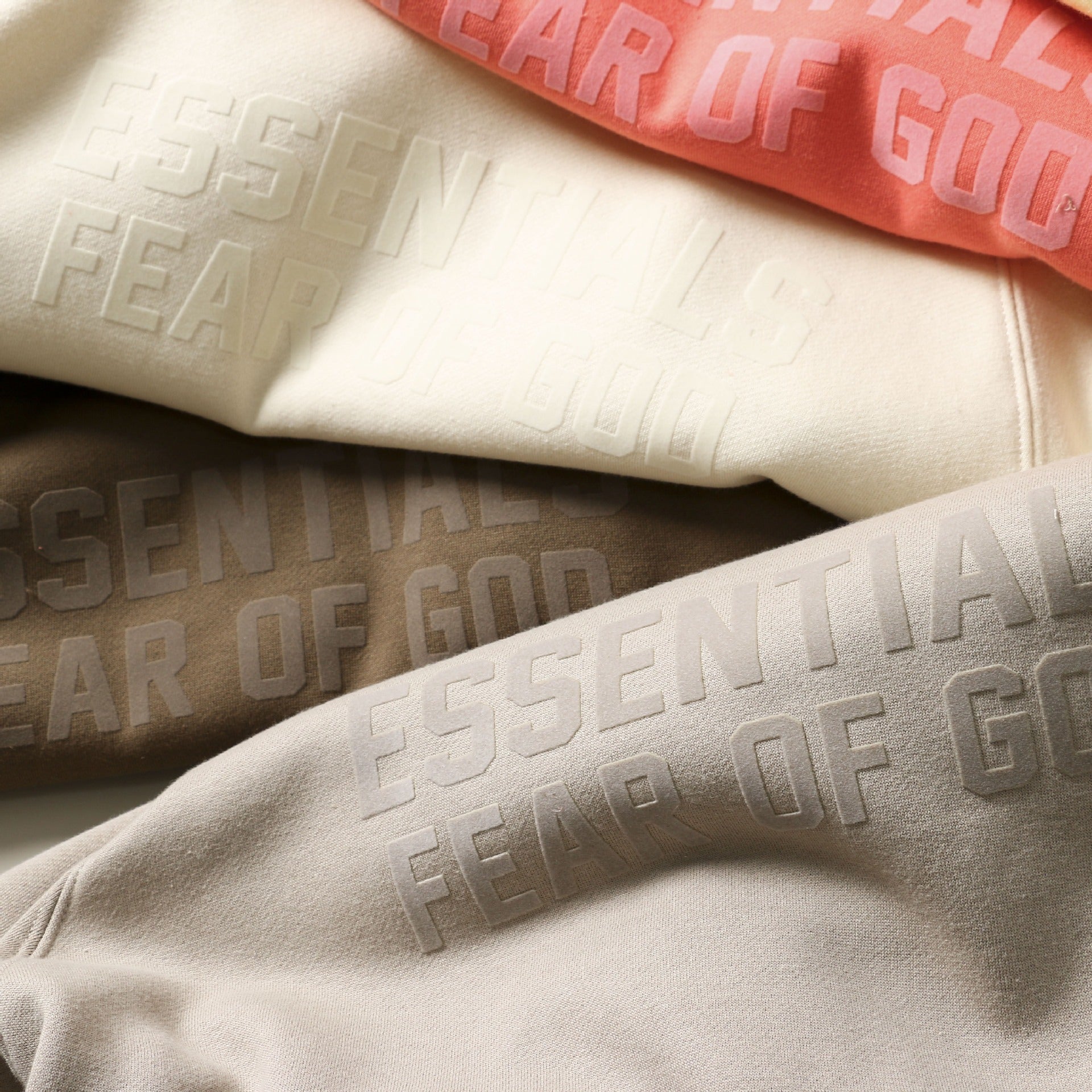 Cozy and stylish hooded plush sweater with bold "Fear of God" branding on a light background