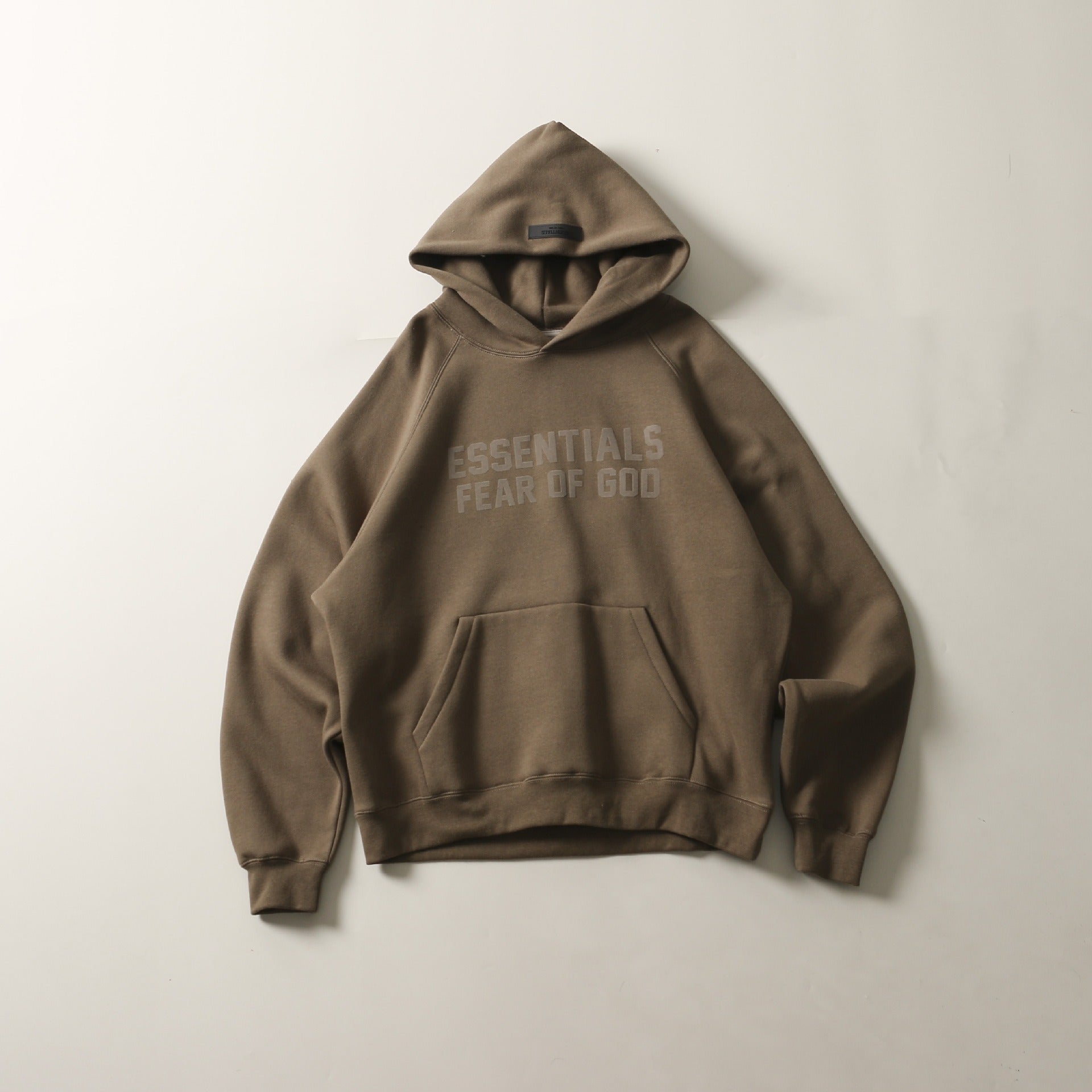 Cozy gray hoodie with "Essentials" text on the front displayed on a plain background