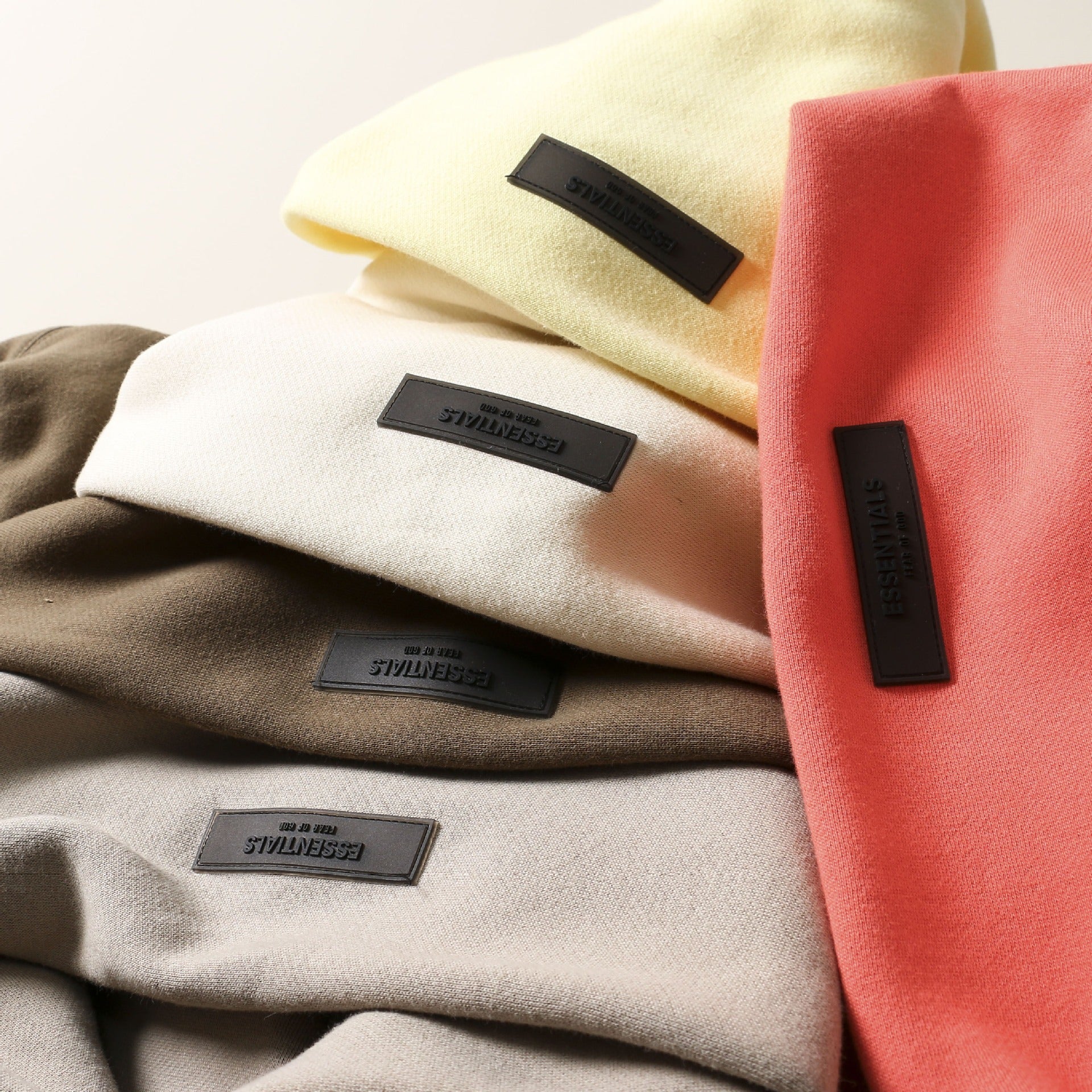 Stylish layered hoodies in neutral tones with branded details on the products in the image.