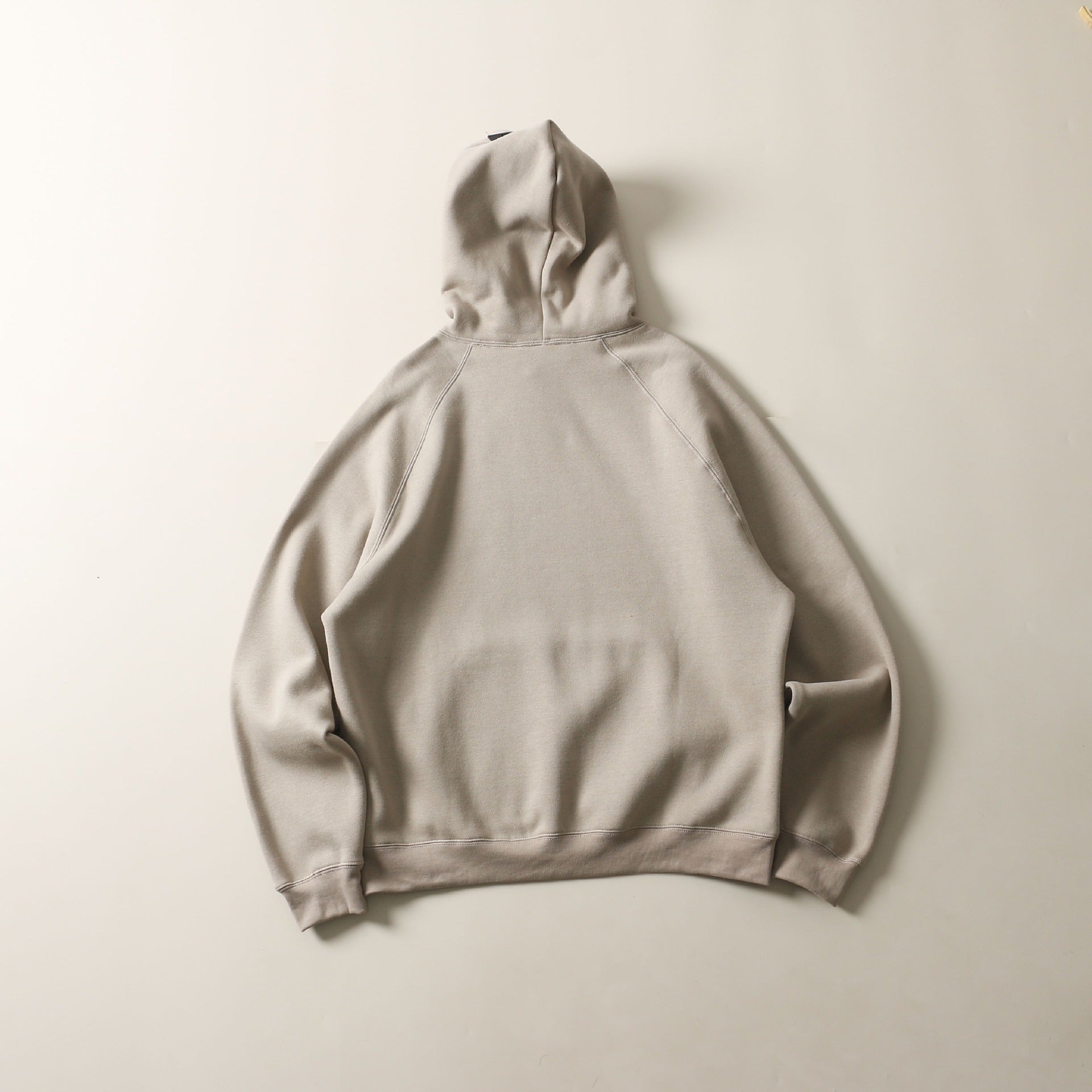 Cozy beige hooded sweatshirt with double row flocked printed design, showcased against a plain white background.